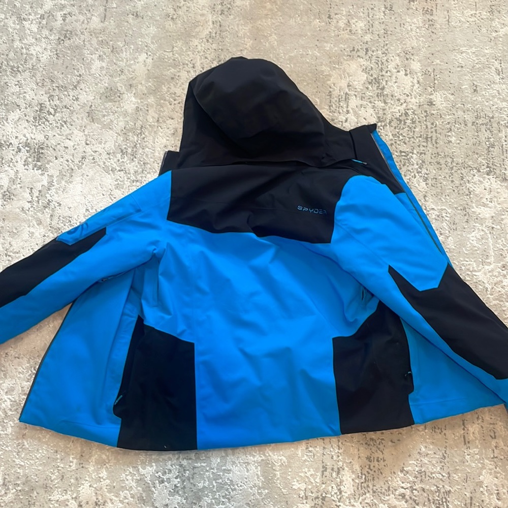 Men’s Spyder ski jacket, size small. It is a bright blue with black.